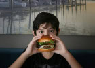 Sortie en famille : fast-food ou resto traditionnel ?  - Enfant tenant un burger  