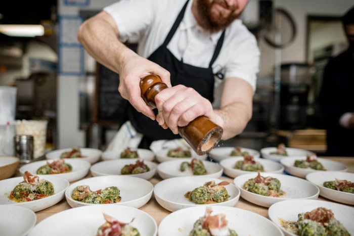  Cuisinier poivrant des plats  