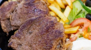 O'malo - Assiette d'entrecôte, avec salade, tomates, oignons, frites, et une sauce au choix