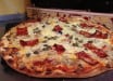 Pizza Nico - pizza à base de creme fraiche et de tomate, viande hachée, oignons poivons...