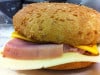 Eaty - Entre 2 buns aux sésames toastés, nous avons glissé, un pavé de jambon fumé, une tranche d’émmental, une tranche de cheddar, quelques rondelles d’oignons et une lichée de sauce à la moutarde à l’ancienne.