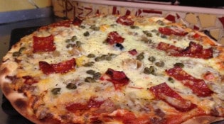 Pizza Nico - pizza à base de creme fraiche et de tomate, viande hachée, oignons poivons...