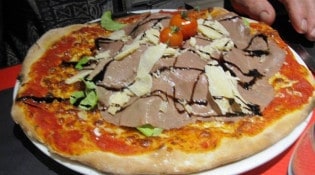 Les coudes sur la table - Une pizza