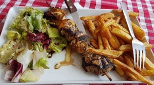 C'chez nous - Une assiette de brochette avec frites et salade